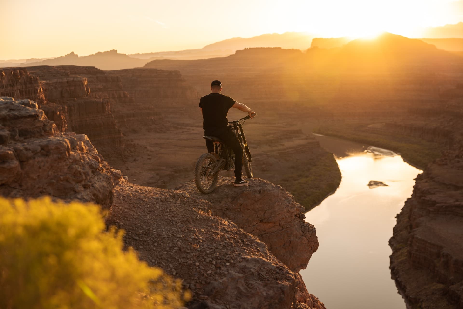 Rider on canyon rim overlooking the Colorado River at golden hour