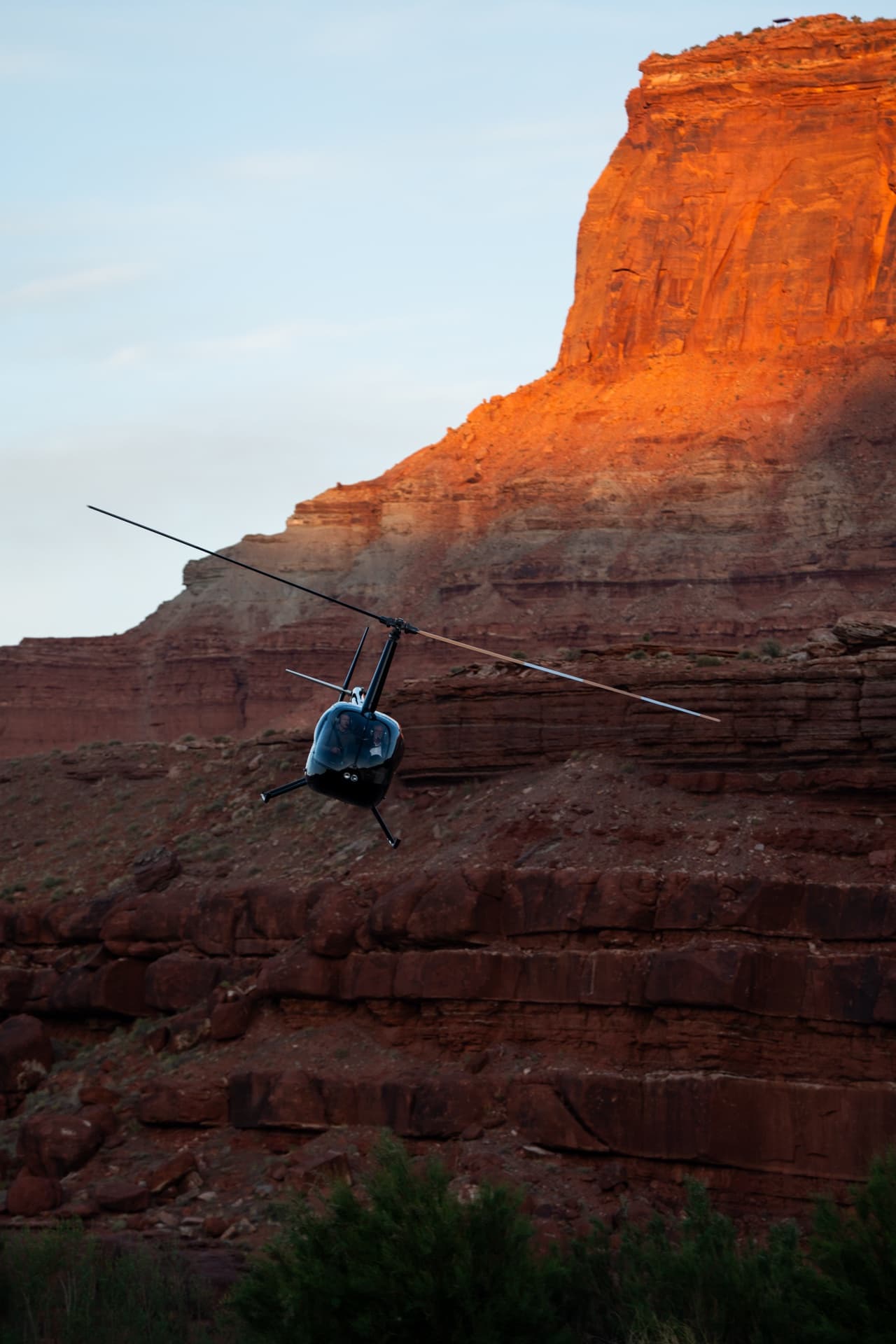 Helicopter banking against canyon walls at golden hour